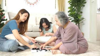 Otistik çocuklu bir aile, tatillerde rahatlamak için oturma odasında oyun oynar.