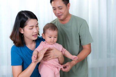 Ebeveynler çocuklarını giydirmeye ve giydirmeye yardım eder.