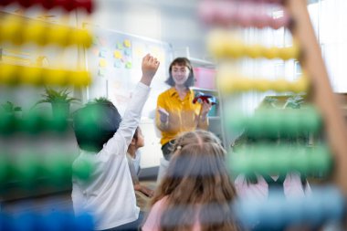 Öğretmen ve öğrenciler, gençlerin dikkatle oturup dinlediği bir okul sınıfında uçakları öğrenin ve öğrenin..