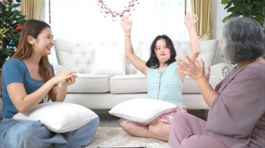 Otistik çocuklu bir aile, tatillerde rahatlamak için oturma odasında oyun oynar.