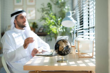 Evde dizüstü bilgisayarda çalışan genç Arap işadamının portresi