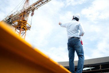 İnşaat alanlarında nesneleri kaldırmak ve taşımak için vinçli mühendis portresi