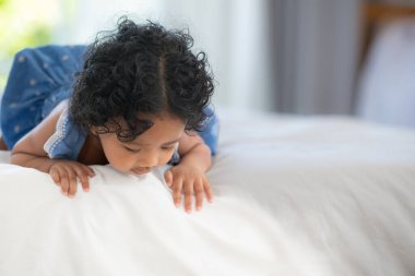 Çocuk evin yatak odasındaki oyuncaklarla mutlu mesut oynuyor.