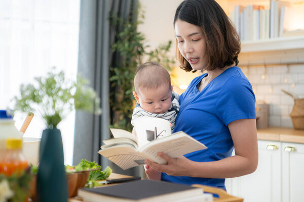 Мать и крошечный ребенок на кухне готовят ужин