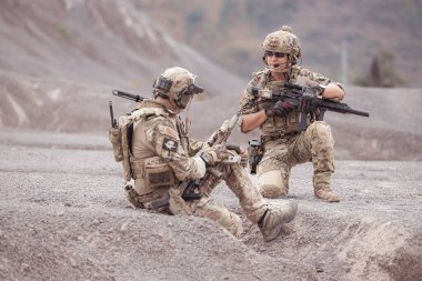 Kamuflaj üniformalı askerler silah taşıyorlar engebeli dağlarda keşif görevleri, saldırı piyade eğitimi alıyorlar..
