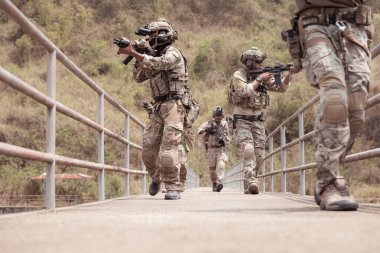 Kamuflaj üniformalı askerler silah taşıyorlar, tropikal orman bölgesinde keşif görevleri, saldırı piyade savaş eğitimi alıyorlar..