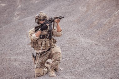 Kamuflaj üniformalı askerler silah taşıyorlar engebeli dağlarda keşif görevleri, saldırı piyade eğitimi alıyorlar..