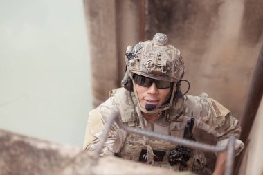 Kamuflaj üniformalı askerler silah taşıyor, tropik orman bölgesinde keşif görevleri yapıyor ve düşmanı gizliyor ve kamufle ediyorlar.