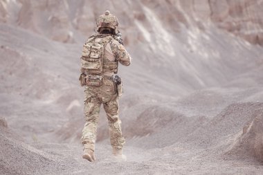 Kamuflaj üniformalı askerler silah taşıyorlar engebeli dağlarda keşif görevleri, saldırı piyade eğitimi alıyorlar..