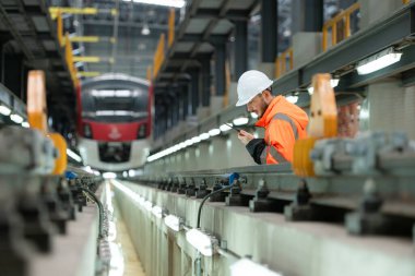 Telsiz kullanan genç bir erkek teknisyenin portresi gökyüzü tamir istasyonunda çalışıyor ve ayakta duruyor..