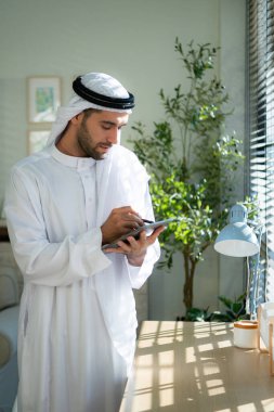 Evde dizüstü bilgisayarda çalışan genç Arap işadamının portresi