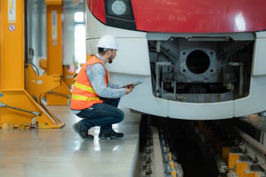 Tablet kullanan genç bir erkek teknisyenin portresi gökyüzü tamir istasyonunda çalışıyor ve ayakta duruyor..