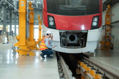 Tablet kullanan genç bir erkek teknisyenin portresi gökyüzü tamir istasyonunda çalışıyor ve ayakta duruyor..