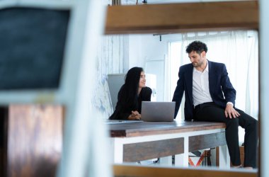 Bir grup profesyonel iş adamı ve iş kadını tablet üzerinde çalışıyorlar. Bir ofis ortamında, gülümsüyorlar ve birlikte çalışıyorlar..