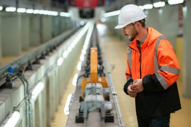 Telsiz kullanan genç bir erkek teknisyenin portresi gökyüzü tamir istasyonunda çalışıyor ve ayakta duruyor..