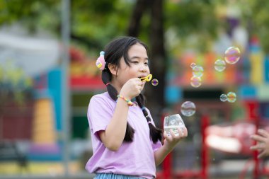 Etrafı yeşillik ve doğa ile çevrili parktaki hava kabarcıklarıyla dolu kızlar.