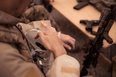 Kamuflaj üniformalı bir grup asker bir çadır kurup savaş eğitimi için hazırlanıyorlar..