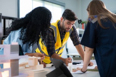 Mühendisler, mimarlar ve tasarımcılar doğal enerji kullanan bir bina tasarlamak için işbirliği yaparlar..