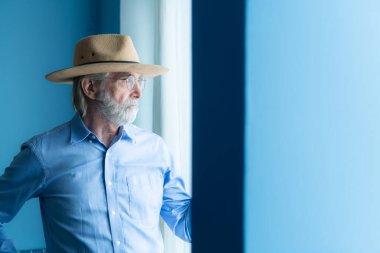 Gülümseyen yaşlı kovboy, saat ve şık şapkalı.