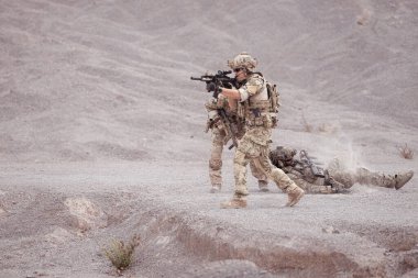 Kamuflaj üniformalı askerler silah taşıyorlar engebeli dağlarda keşif görevleri, saldırı piyade eğitimi alıyorlar..