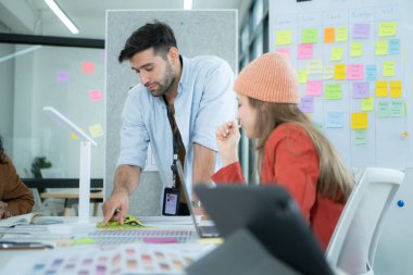 Modern ofiste birlikte çalışan çok ırklı genç iş adamları, internet ağında kullanım için bir uygulama tasarlamada işbirliği yaparlar..