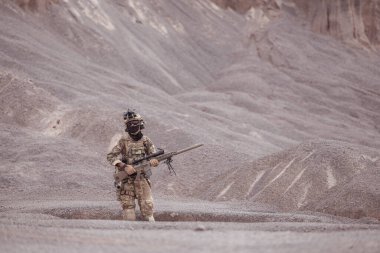 Kamuflaj üniformalı askerler silah taşıyorlar engebeli dağlarda keşif görevleri, saldırı piyade eğitimi alıyorlar..
