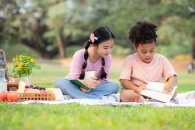 Mutlu bir aile parkta piknik yapıyor, Çocuklar kağıda resim çizerken eğleniyor..