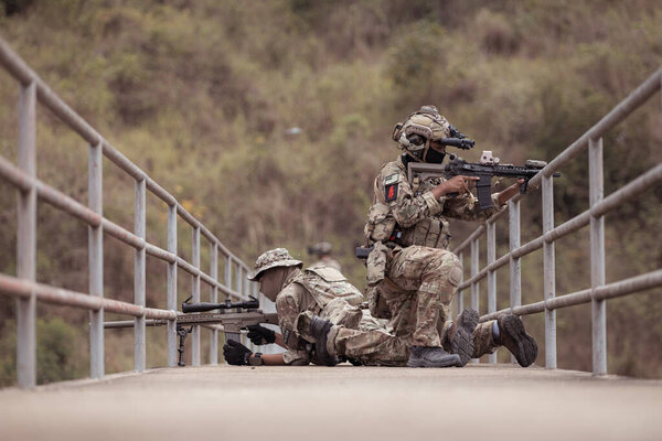 Солдаты в камуфляжной военной форме с оружием, разведывательные миссии в тропических лесах, боевая подготовка пехоты.