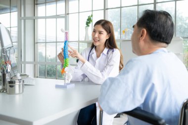 In the hospital office, A medical explains about the spine and its treatment to a patient clipart