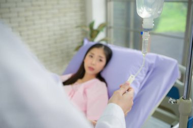 Serum takan kadın doktor serum verecek ve hastaları hastane yatağında muayene edecek.