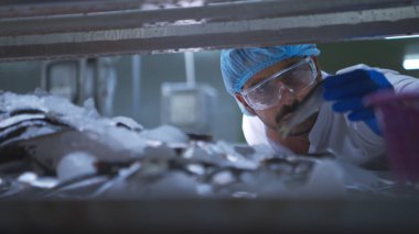 Hammadde kalitesi müfettişleri balık parçalarını konserve balık üretim sürecine girmeden önce değerlendirir ve inceler.