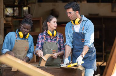 Marangoz ve asistanı bir marangozluk atölyesinde birlikte çalışıyorlar.