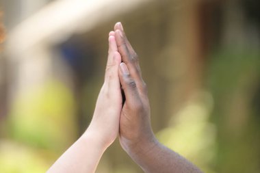 Afrikalı bir adam ve Asyalı bir adamın ellerine yakın çekim.