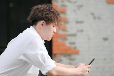 Saç stili ve toplum içinde yaşama havası olan genç bir adam..