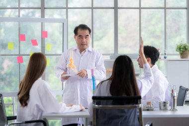 Bir tıp profesörü, tıp öğrencilerine hastalık tedavisi ile ilgili bir vaka üzerinde ders veriyor.