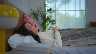 Yatak odasındaki yatağında uyuyan Asyalı genç kadın.