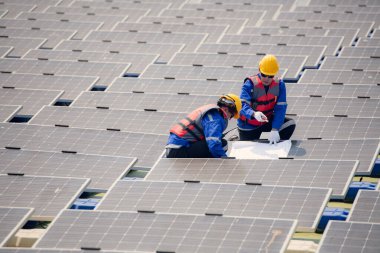 Fotovoltaik mühendisleri yüzen fotovoltaikler üzerinde çalışıyorlar. Suda yüzen güneş paneli ekipmanlarını incele ve onar.