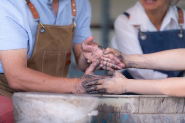 Çömlekçilik atölyesinde birlikte faaliyet gösteren yaşlı bir Asyalı çiftin portresi..