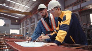 Mühendisler ve mimarlardan oluşan bir ekip fabrika alanında proje üzerinde çalışıyor. Metal levhaların yanı sıra taşımacılık ve dağıtım deposu yapmak için çok büyük bir tesis..