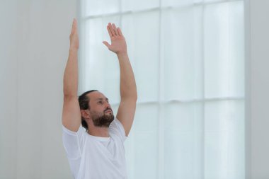 Güzel genç adam evde yoga yapıyor. Yoga asana.