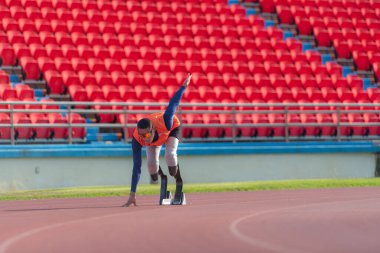 Engelli sporcular başlangıç pozisyonunda stadyum pistinde koşmaya hazır olun.