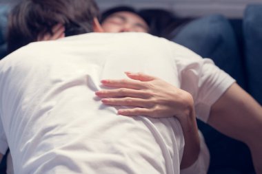 Evdeki oturma odasında, iç çamaşırlı seksi bir kadın eşine aşık bir şekilde kanepede yatıyor..