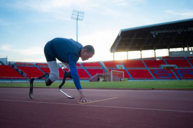 Engelli sporcular başlangıç pozisyonunda stadyum pistinde koşmaya hazır olun.