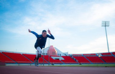 Disabled athletes prepare in starting position ready to run on stadium track clipart