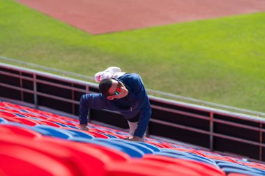 Engelli sporcular, kısa mesafe koşusuna katılmadan önce güneşli bir günde spor sahasında vücutlarını amfitiyatroda hazırlıyorlar.