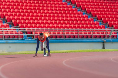 Engelli sporcular başlangıç pozisyonunda stadyum pistinde koşmaya hazır olun.