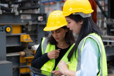 Metal levha fabrikasında birlikte çalışan iki kadın mühendis. Burası bir nakliye ve dağıtım deposu. Sanayi ve sanayi işçileri kavramı