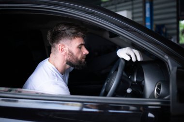 Araba tamirhanesinde çalışan genç bir araç teknisyeni..