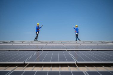 Her iki teknisyen de fotovoltaik güneş panelleri üzerinde çalışıyor.