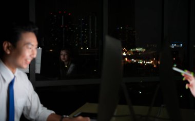 Her iki Asyalı genç borsacı uluslararası borsa simsarları gece ofisindeki masaüstünde birlikte çalışıyorlar. Uluslararası finans şirketi konsepti.